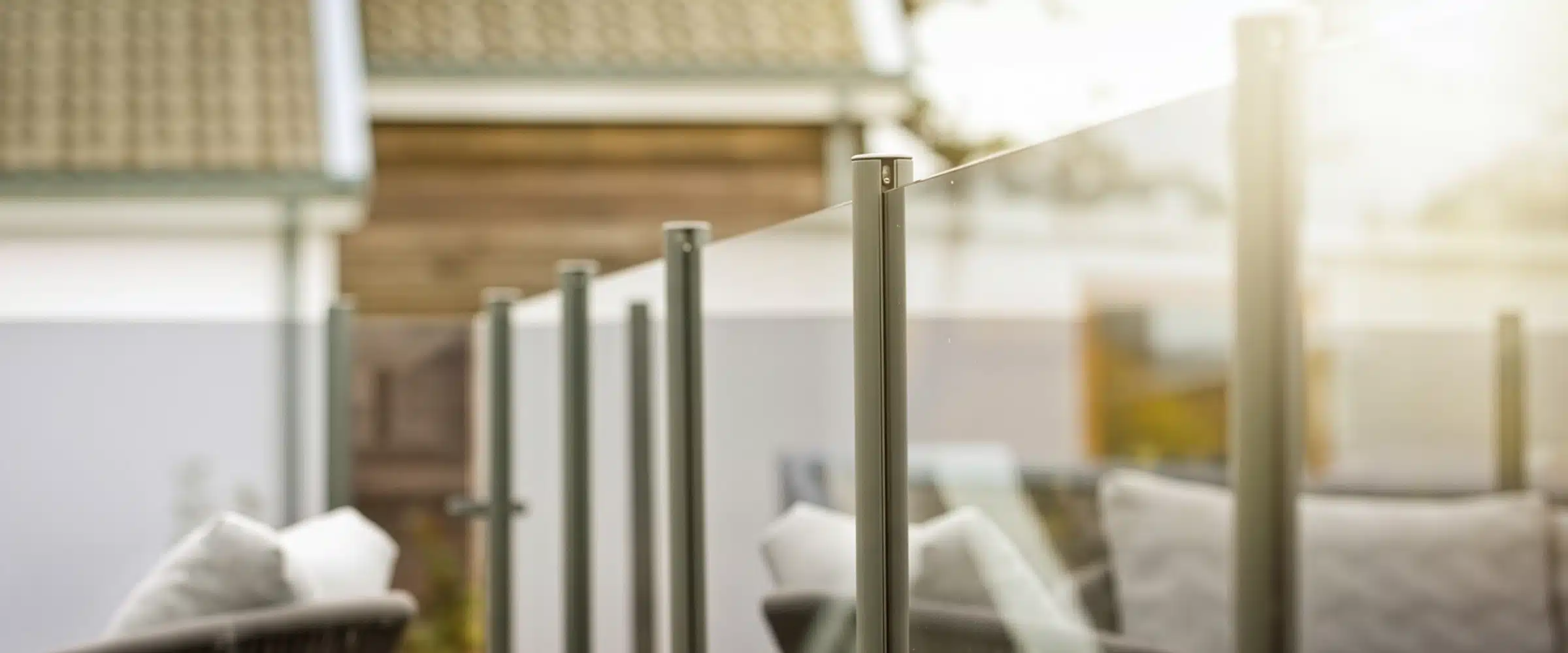 Glasgelænder med aluminiumsstolper på en terrasse, monteret af Gelænderbutikken.